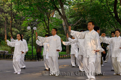 Morning Tai Chi exercise class under trees in Zizhuyuan Purple Bamboo Park in Beijing China