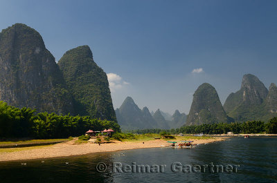 Boats and rest stop on the Li river China with tall karst formations receding into the distance