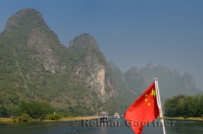 Chinese flag on a cruise ship on the Lijiang river Guangxi China with tall karst peaks