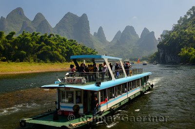 Tour boat cruise down the Li river with bamboo forest and hazy karst peaks