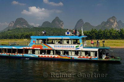 Chinese tour boat at Yangshuo on the Li river Guangxi China with bamboo and karst peaks