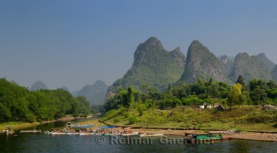 Tour boat rafts on the shore of the Li river Guangxi China with karst mountain peaks