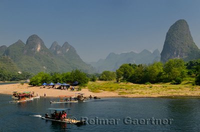 Tour boat rafts at rest stop on the Li river Guangxi China with tall karst mountain cones
