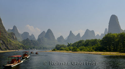 Panorama of tour boat rafts on the Li river Guangxi China with fingerlike karst mountain peaks