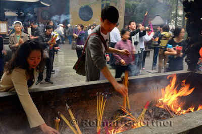 People praying for blessings placing incense sticks at the Ling Yin Buddhist temple Hangzhou China
