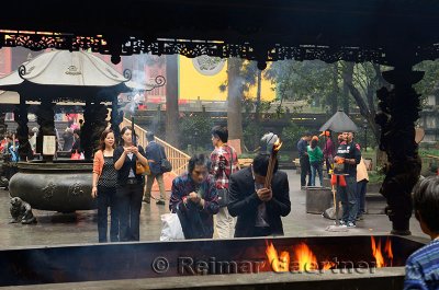 People bowing with incense sticks and praying for blessings at the Ling Yin Buddhist temple Hangzhou China