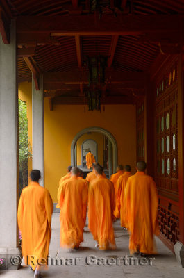 Buddhist monks in orange robes congregating at the dining hall of the Ling Yin Temple in Hangzhou China