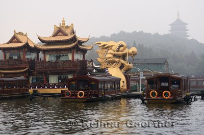 Golden Dragon Boat at West Lake Pleasure boat dock and Leifeng Pagoda Hangzhou China