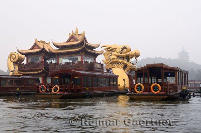 Golden Dragon Boat barge on West Lake with Leifeng Pagoda in Hangzhou China