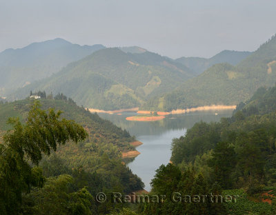 Boat on Feng Le Shenxiu Lake scenic area with mountains Huizhou District Huangshan China