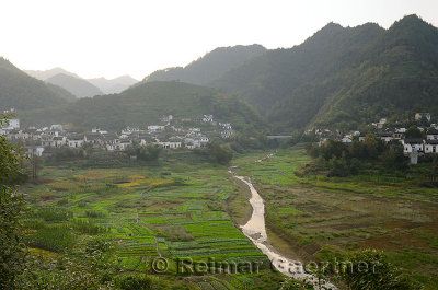 Mountains and farms of Qiashe Xiang village on flood plain of Fengle river Huangshan China