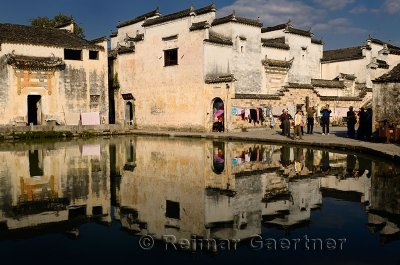 Ancient white buildings reflected in the still Half moon pond in Hongcun village China