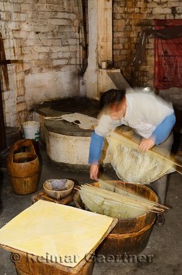 Chinese worker making tofu from bean curds in a shop in ancient Chengkan village China