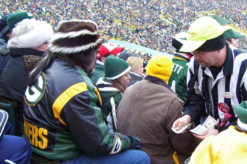 Beer man selling skunky beer to man in skunky hat.