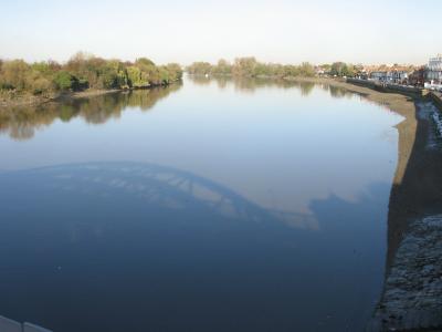 Looking down from bridge. The blue is the sky reflection. This river is brown.