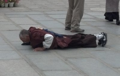Buddhist pilgrims progress by body length well into the night