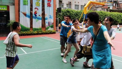 IBM volunteers play Eagle-Chick Game with the children
