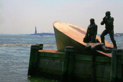 Memorial for fallen sailors with Statue of Liberty behind it