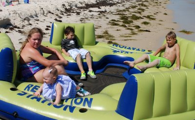 Kylie, Carter, and Brooks are relaxing on the big raft...though Bella wants none of it