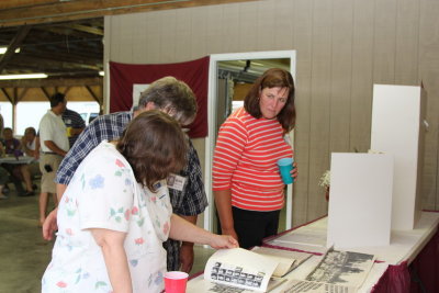 Kathy Schneep Carpenter and the Waldrons view the year books and memorial to lost classmates