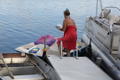 Mariann Anthony boarding her peddle boat to return to her mom's across the lake