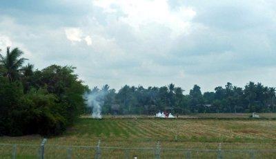 Burning Rice Field Stubble Near Family Gravesites in the Field