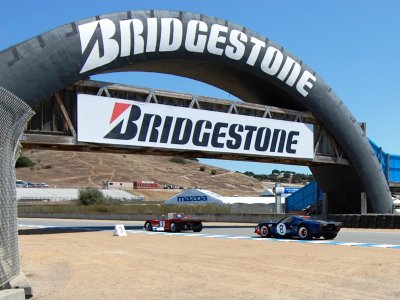 Ford GT chaseing Ferrari through Laguna Seca tire bridge