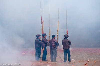 China (Guizhou) - Pipers Amid Firecracker Smoke  