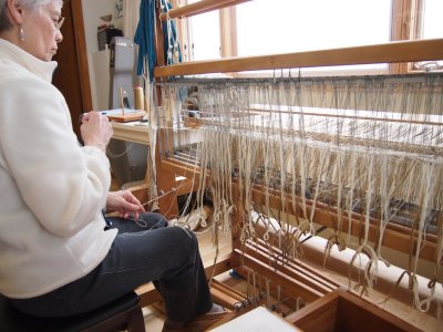 Warp almost completely threaded through heddles.