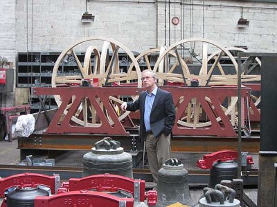 alan hughes, master bellfounder in front of a bell frame