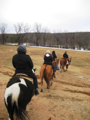 Horseback riding through an open pasture