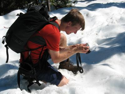 I think he's taking a picture of his face in the snow