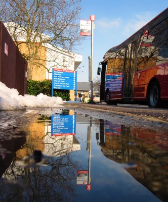 London  Bus  reflected  in  melting  snow.