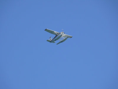 A float plane flying over the boat