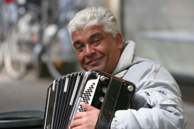 A man with an accordion, playing soft tunes for the pedestrians