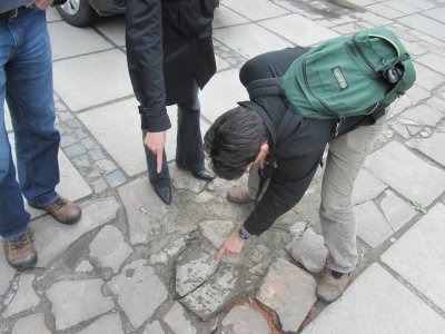 Alex F. with a headstone used as paving on the square where the central synagogue once stood