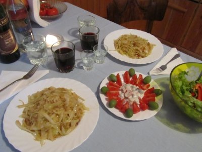 fried cabbage, herring with tomatoes and olives, and salad