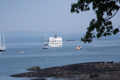 A cruise ship sits off shore as....