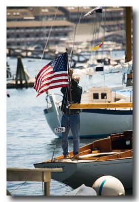 ....antique boat parade (man afixes flag to 1935 Rhodes sailboat).