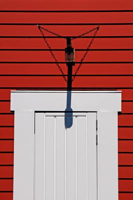 White door, red wall and lamp shadow