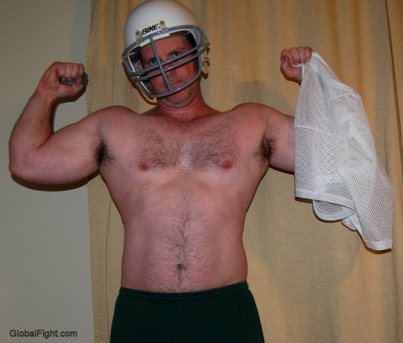 man wearing footbal helmet undressing removed jersey.jpg