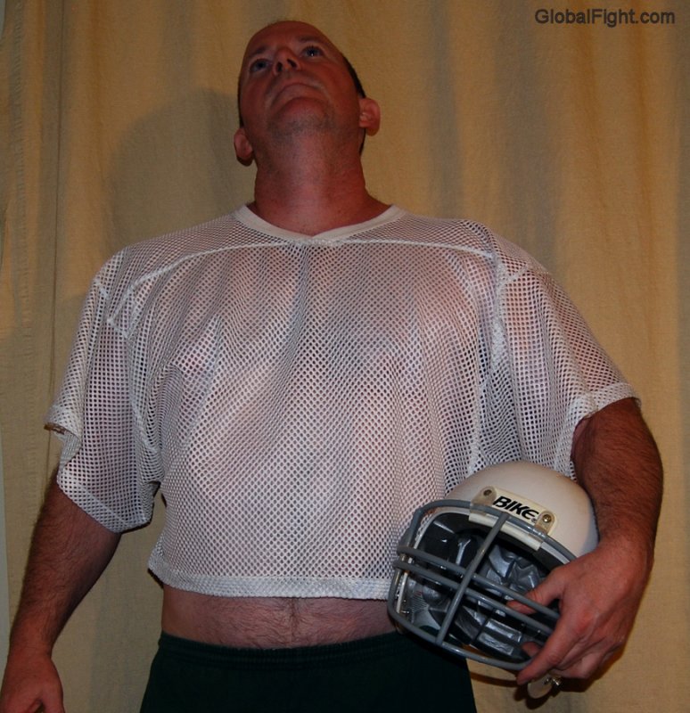 football player wearing jersey shorts holding helmet.jpg