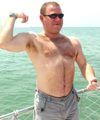 very hairy daddy bear flexing big muscles on boat.jpg