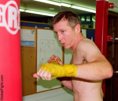 younger boxer boy hands wrapped hitting bag.jpg