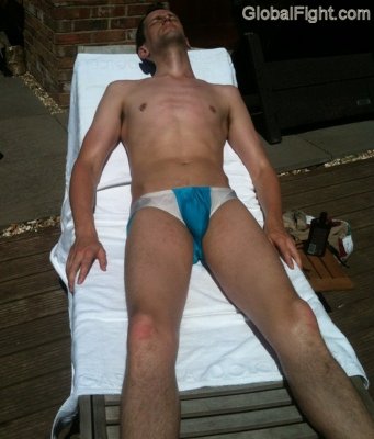 boy suntanning poolside laying on deck chair.jpg