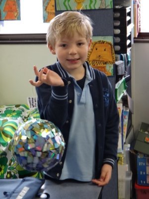 Archer and the disco ball he made from recycled CDs