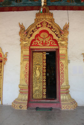 The ornate, golden entrance door of Wat Aham temple.