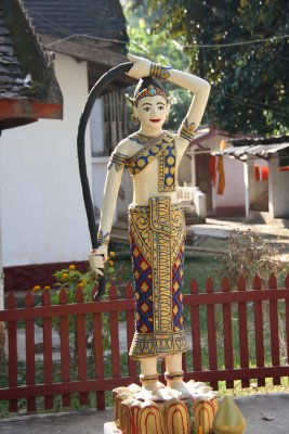 Statue of a woman at Wat Visoun temple holding a naga (snake), which is sacred in Buddhism.