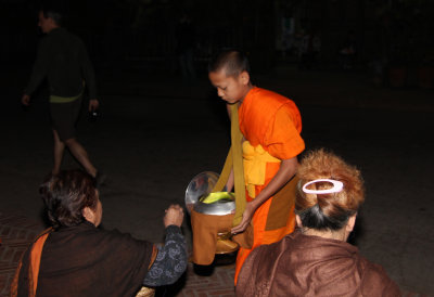 Young Lao monk receiving alms.