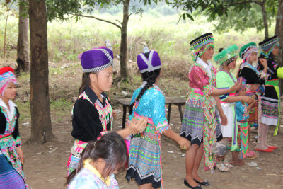 The children dress in beautiful colored and decorative clothing with beads and hats.